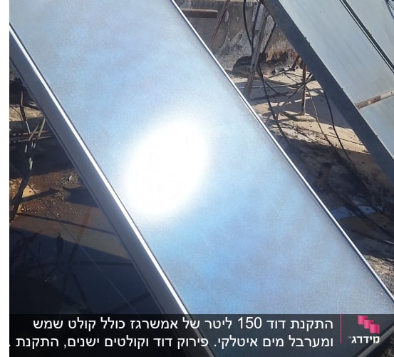קולטי שמש על גג עם דודי שמש ברקע